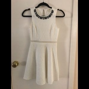 white sleeveless dress with black beaded neckline